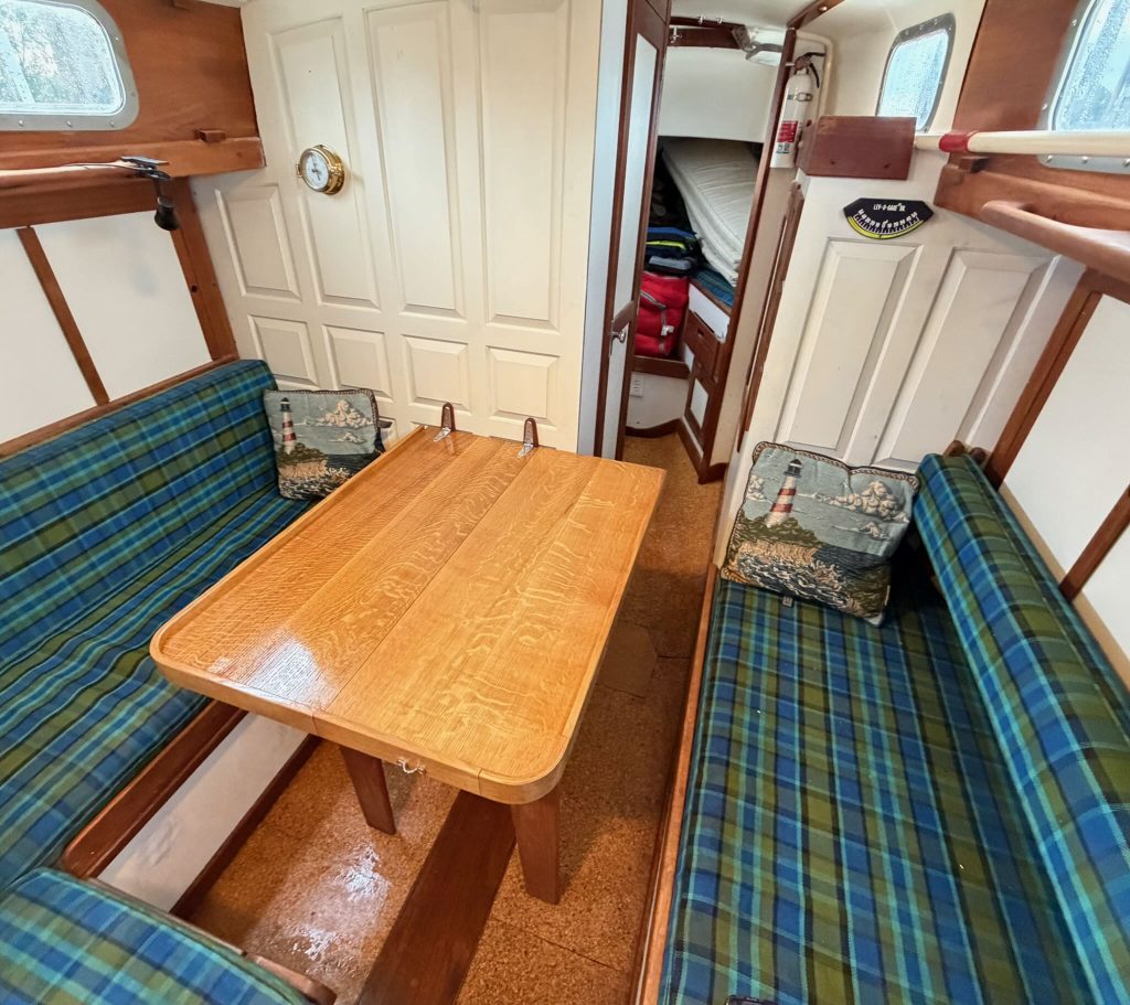 The saloon, featuring green tartan upholstery and a newly finished maple tabletop.  The cork sole is visible underneath.